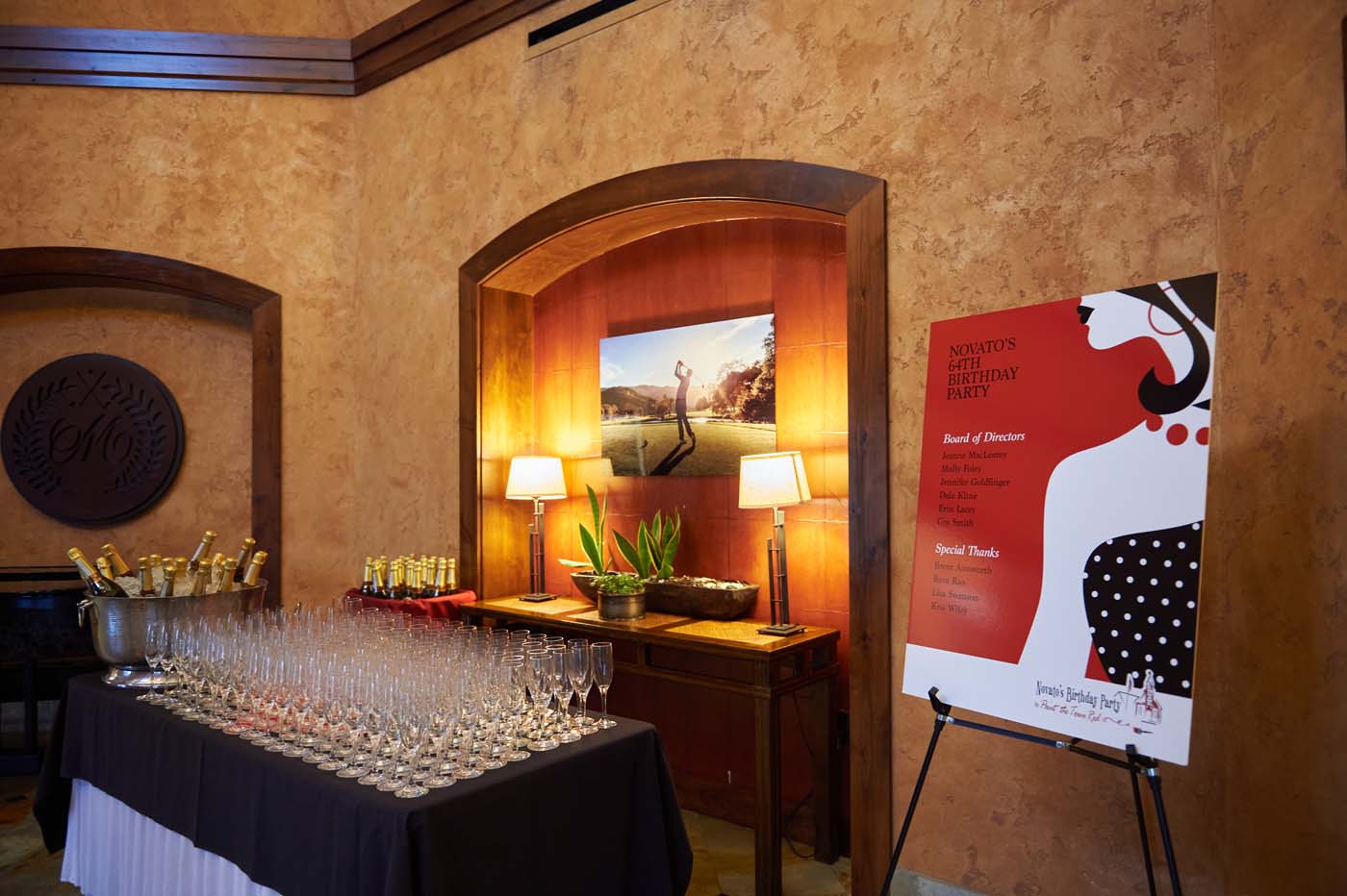 a beverage table with glasses and bottles of champagne