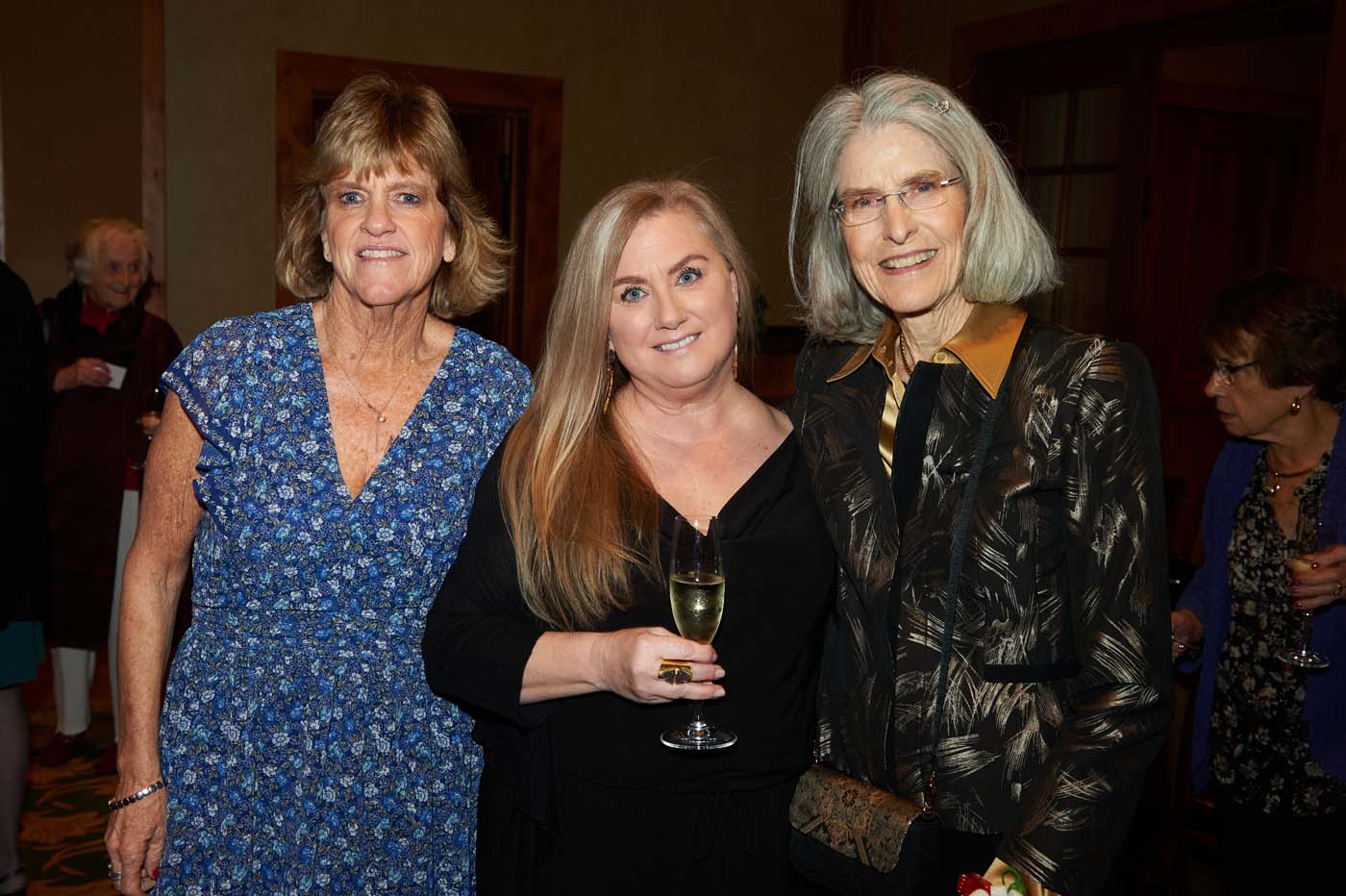 three woman smiling and standing together