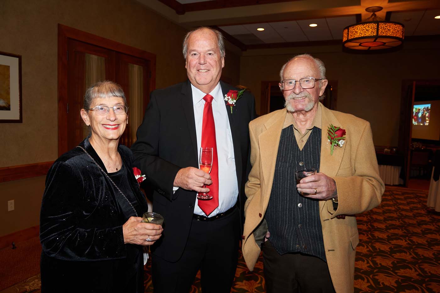 a group of three people standing and smiling together