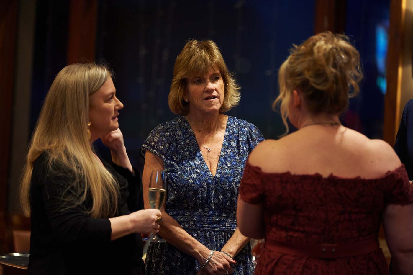 three women standing and talking to each other