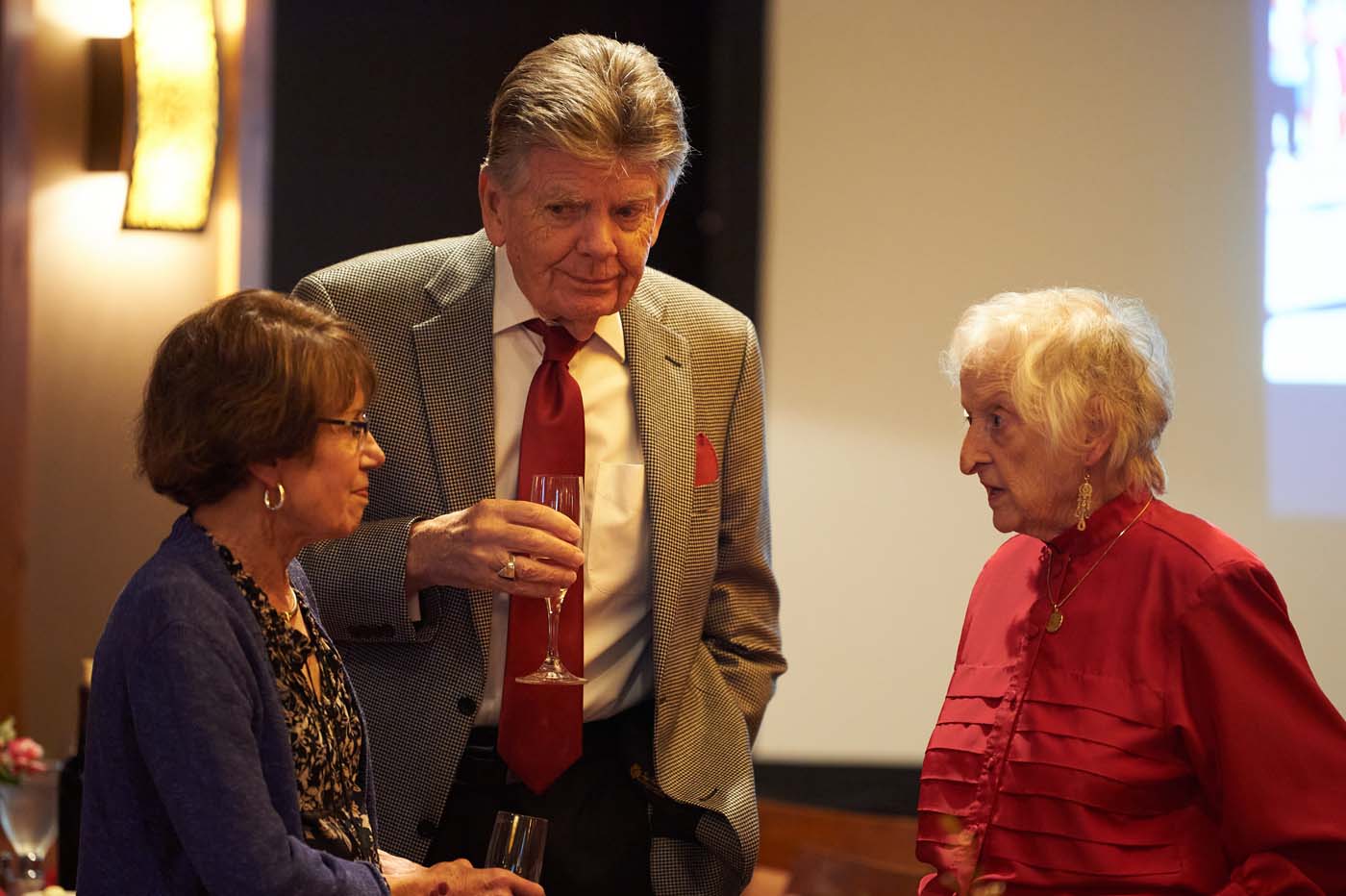 three people standing and talking with each other