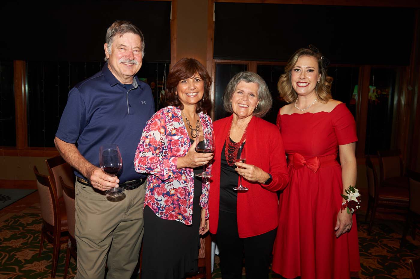 a group of four people standing and smiling together