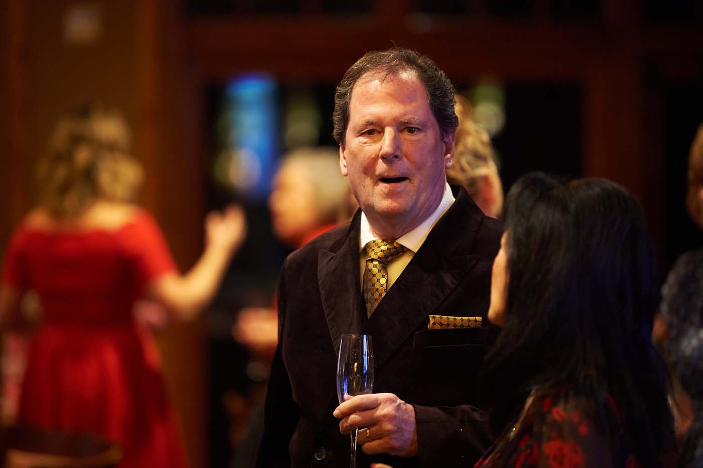a man standing holding a champagne flute