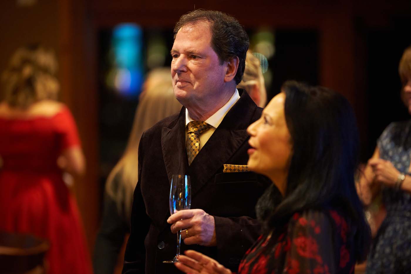 a man standing holding a champagne flute