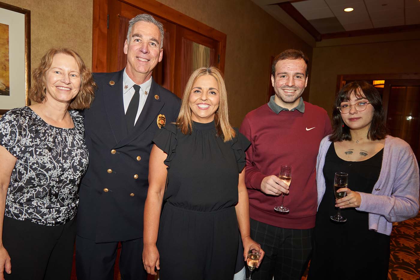 a group of five people standing and smiling together