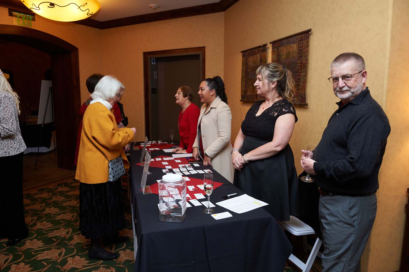 a group of people helping guests sign-in and find their name tags