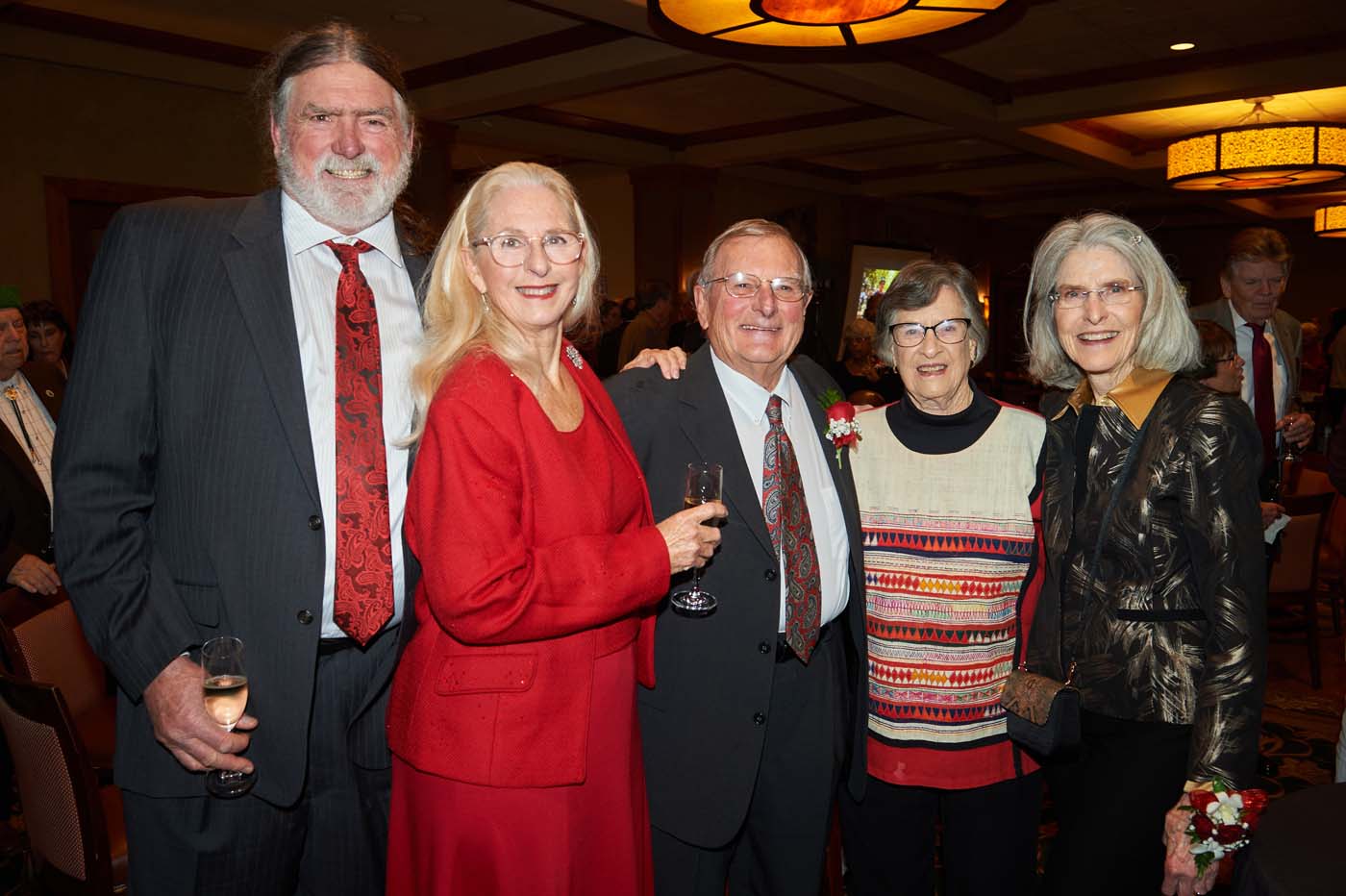 a group of five people standing and smiling together