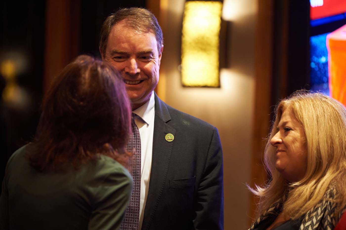 a group of three people talking to each other