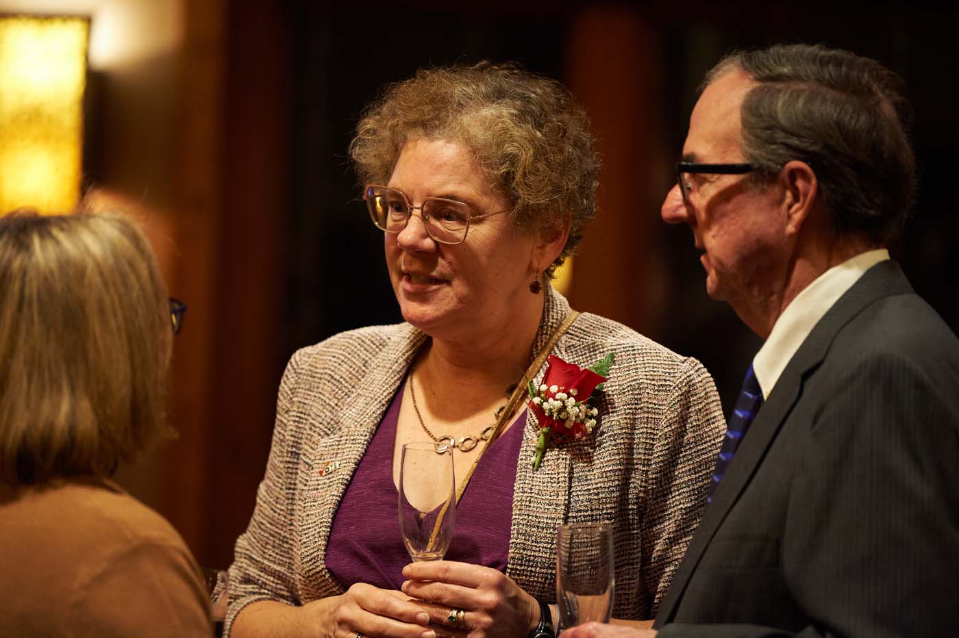 a group of three people standing and talking to each other