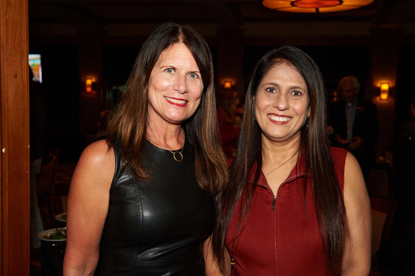 two women standing and smiling together