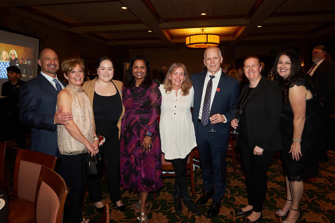 a group of eight people standing and smiling together