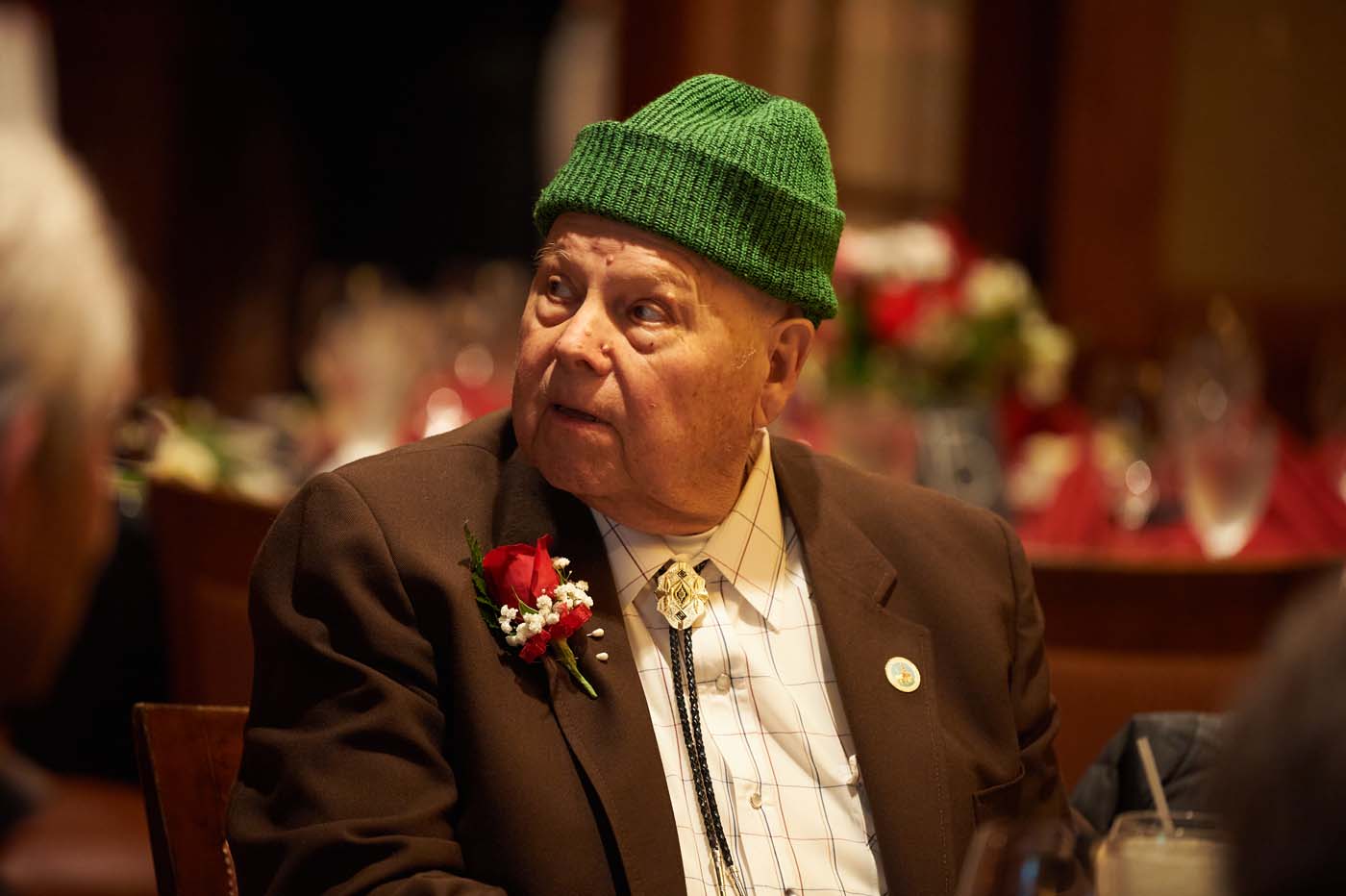 a man with a green hat sitting at a table
