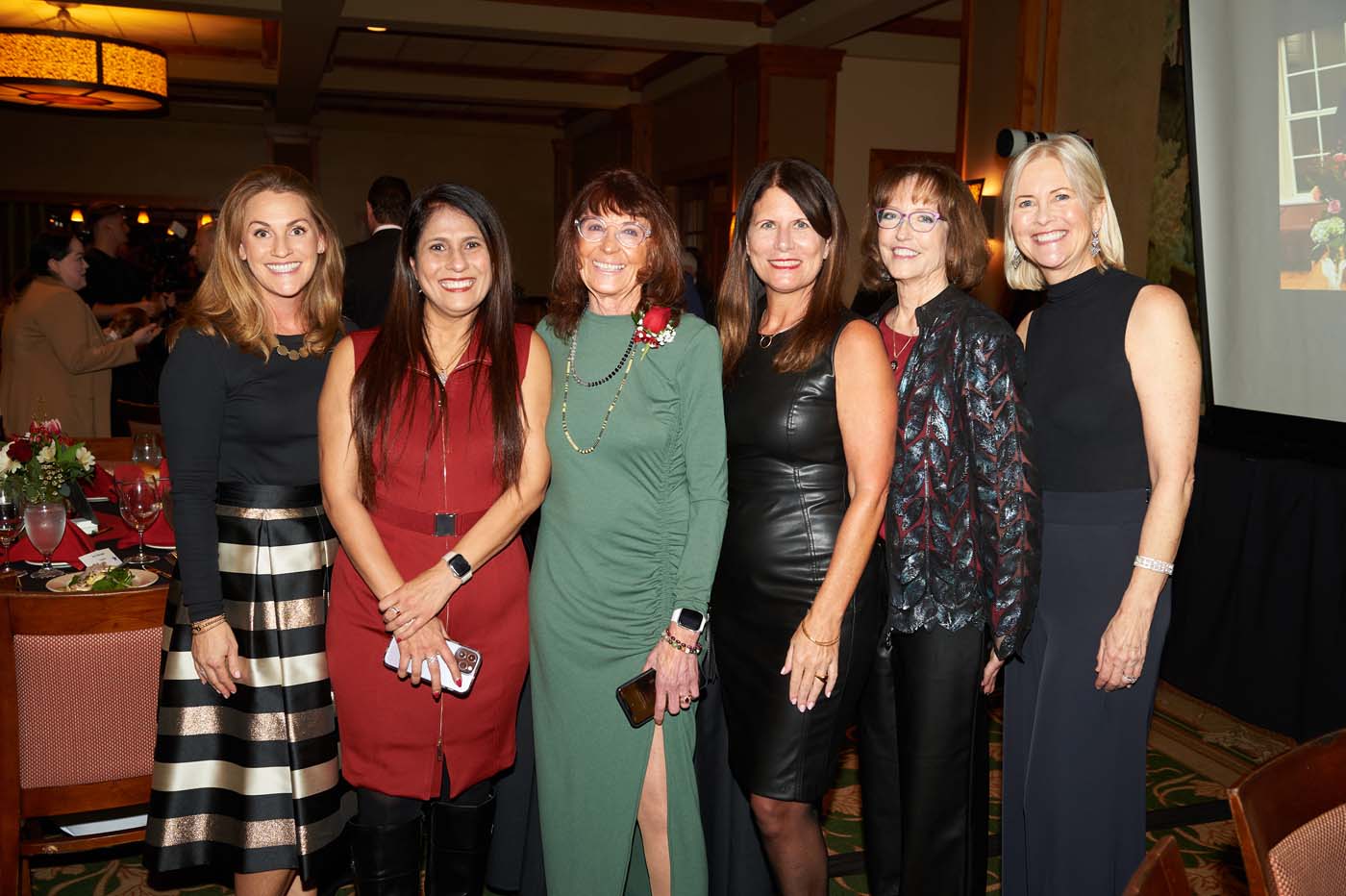 a group of six women standing and smiling together