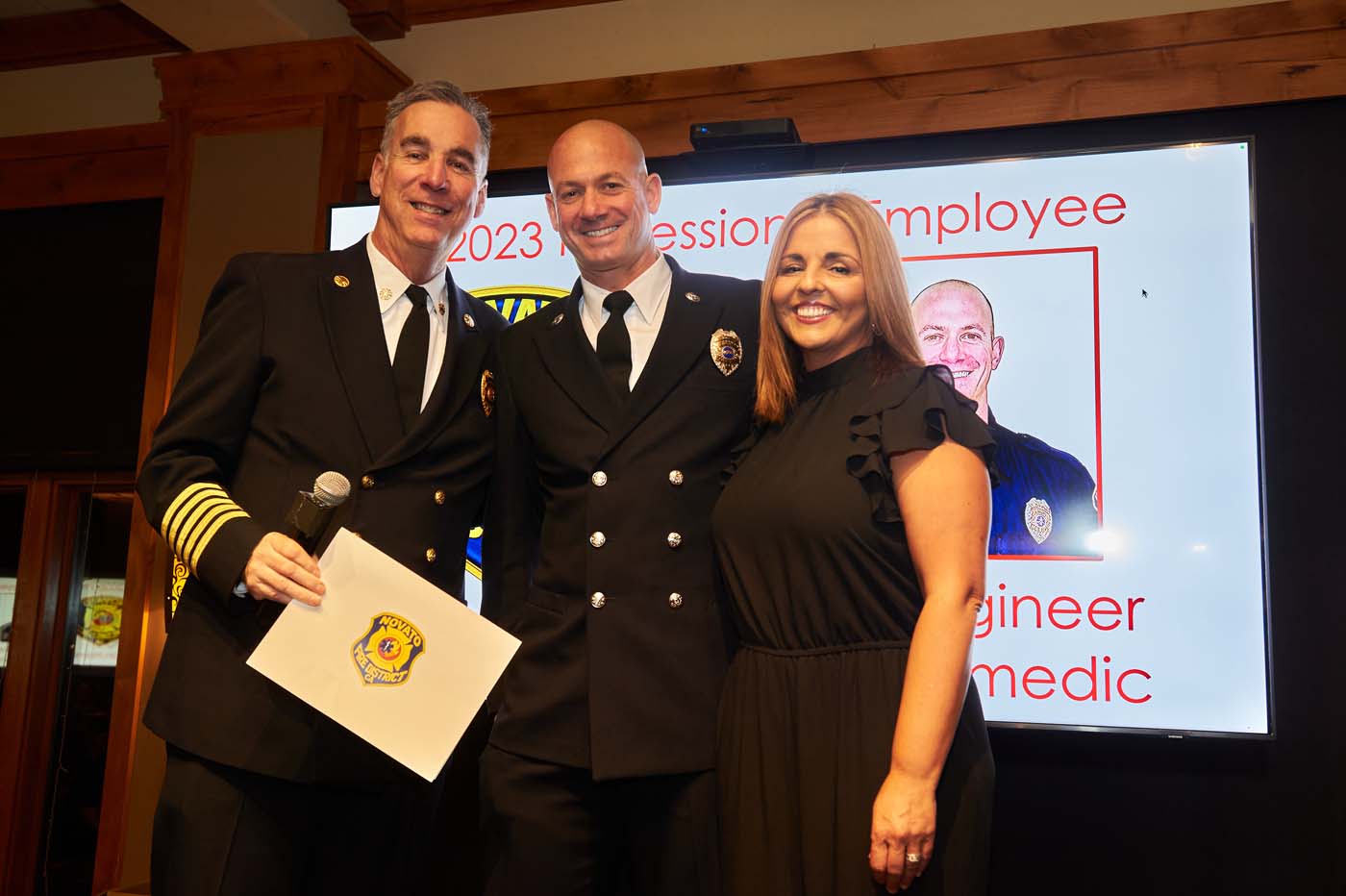 three people standing on a stage accepting an award