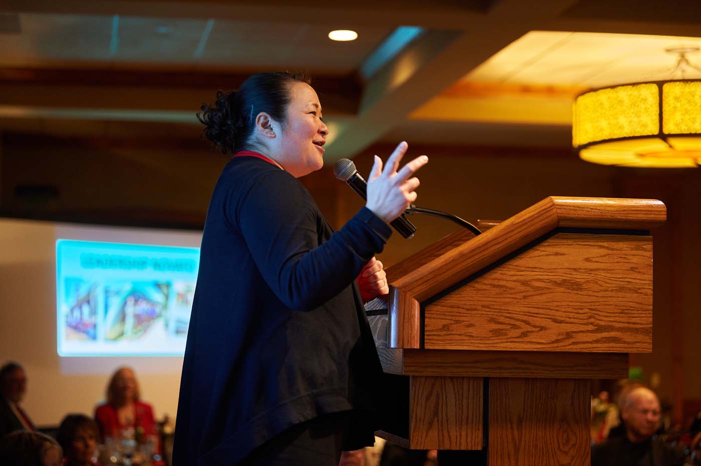 a woman at a pedestal with a microphone