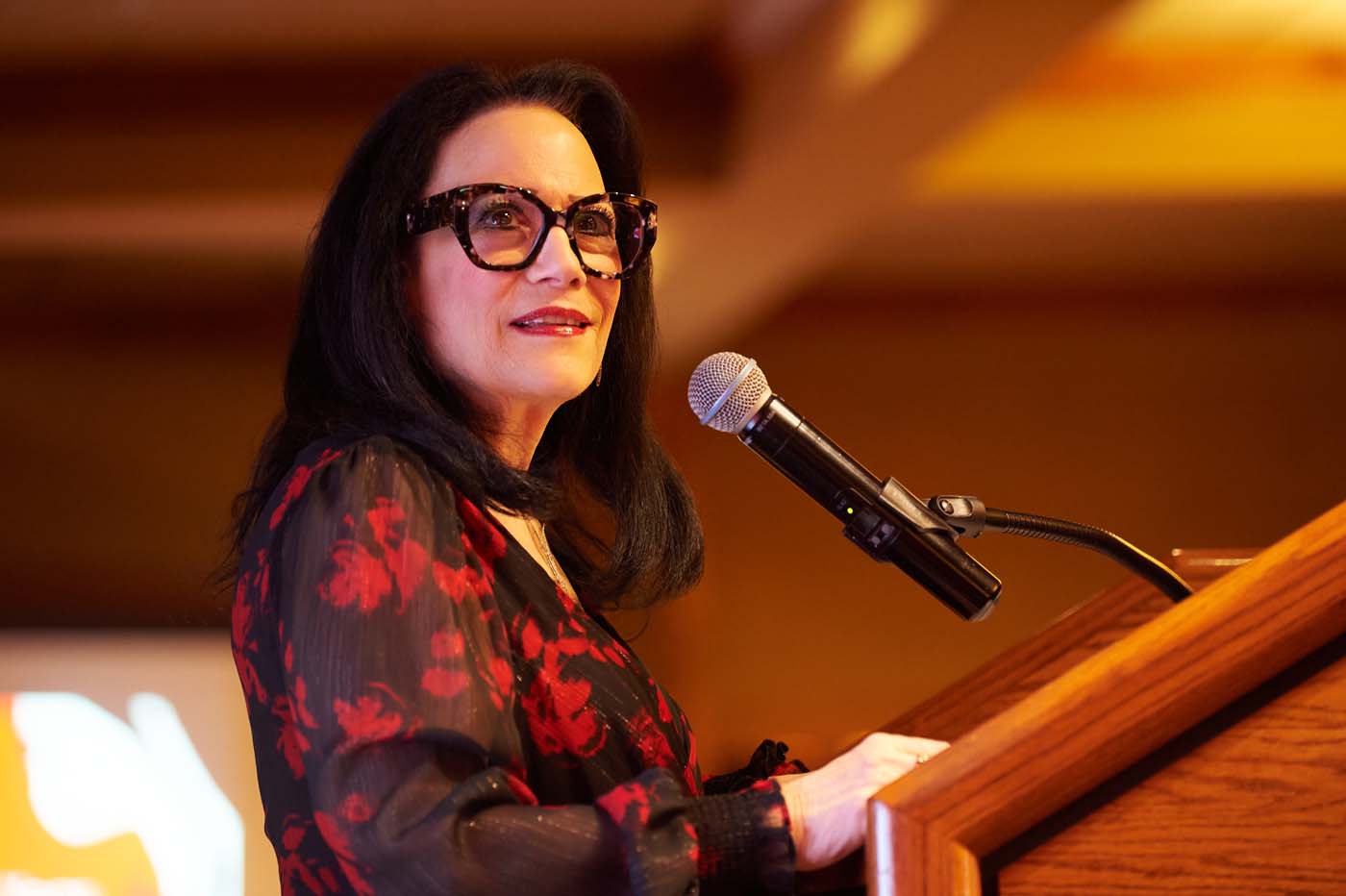 a woman at a pedestal with a microphone