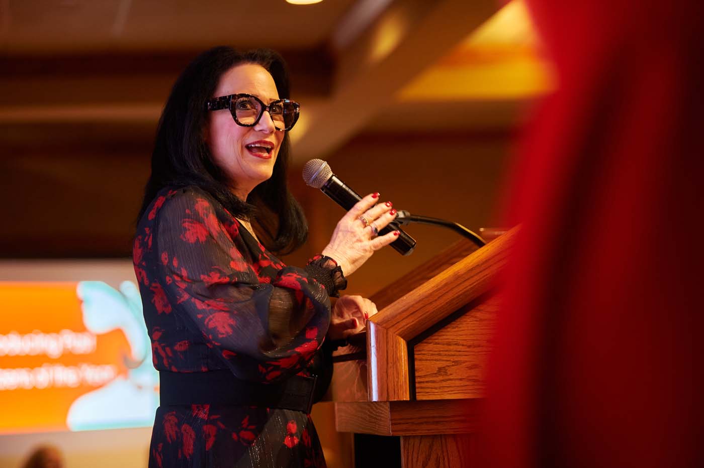 a woman at a pedestal with a microphone
