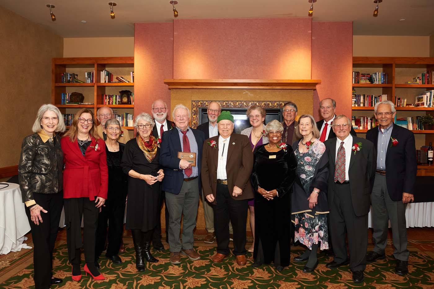A group of people posing, with one man holding a plaque